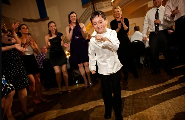 Young boy dancing at a wedding reception