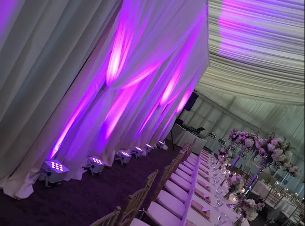 Elegant venue with purple uplighting and floral arrangements